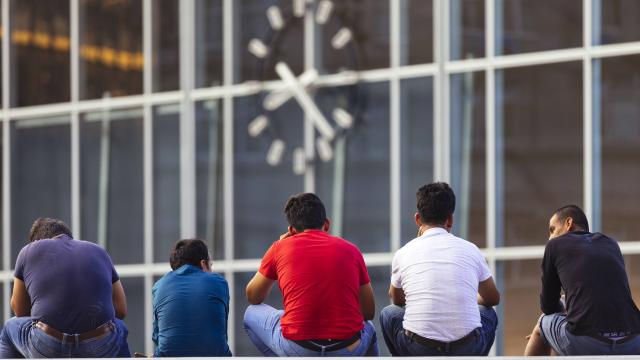 Migranten sitzen auf der Bahnhofstreppe am Kölner Hauptbahnhof.