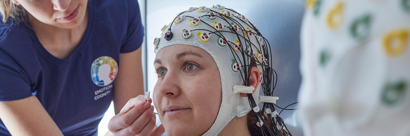 Forscherin befestigt Elektroden an der EEG-Haube
