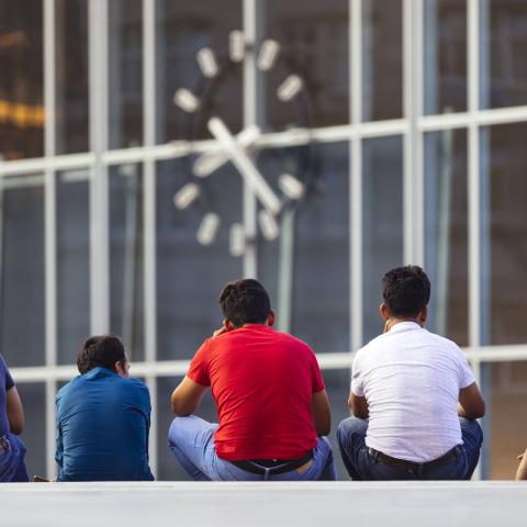 Migranten sitzen auf der Bahnhofstreppe am Kölner Hauptbahnhof.