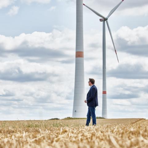 Oliver Koch vor zwei Windkraftanlagen.