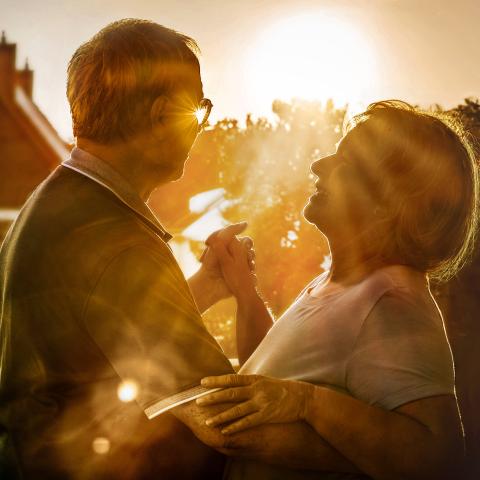 Älteres Ehepaar tanzt in den Sonnenuntergang